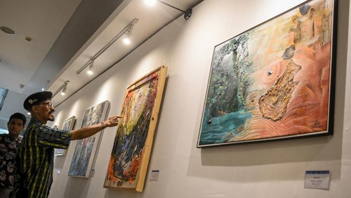 Pengunjung mengamati karya lukis dalam Pameran Archipelago di Museum Basoeki Abdullah, Jakarta, Jumat (14/6/2024). Komunitas Perupa Kota Tua menyelenggarakan pameran lukisan karya 20 perupa bertajuk Artchipelago yang mencerminkan semangat kebersamaan dan kebhinekaan dalam konteks global yang berlangsung hingga 30 Juni 2024. ANTARA FOTO/Sulthony Hasaanuddin/rwa.
