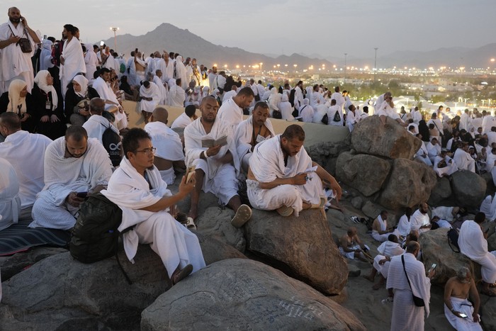 Muslim pilgrims gather at the top of the rocky hill known as the Mountain of Mercy, on the Plain of Arafat, during the annual Hajj pilgrimage, near the holy city of Mecca, Saudi Arabia, Saturday, June 15, 2024. Masses of Muslims gathered at the sacred hill of Mount Arafat in Saudi Arabia for worship and reflection on the second day of the Hajj pilgrimage. The ritual at Mount Arafat, known as the hill of mercy, is considered the peak of the Hajj. Its often the most memorable event for pilgrims, who stand shoulder to shoulder, asking God for mercy, blessings, prosperity and good health. Hajj is one of the largest religious gatherings on earth. (AP Photo/Rafiq Maqbool)