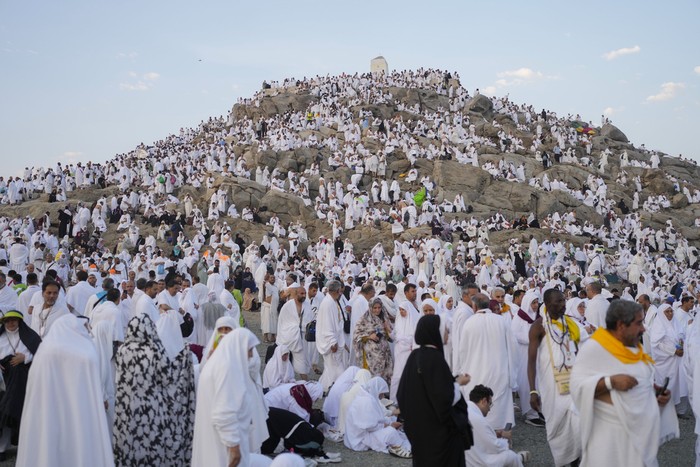 Muslim pilgrims gather at the top of the rocky hill known as the Mountain of Mercy, on the Plain of Arafat, during the annual Hajj pilgrimage, near the holy city of Mecca, Saudi Arabia, Saturday, June 15, 2024. Masses of Muslims gathered at the sacred hill of Mount Arafat in Saudi Arabia for worship and reflection on the second day of the Hajj pilgrimage. The ritual at Mount Arafat, known as the hill of mercy, is considered the peak of the Hajj. Its often the most memorable event for pilgrims, who stand shoulder to shoulder, asking God for mercy, blessings, prosperity and good health. Hajj is one of the largest religious gatherings on earth. (AP Photo/Rafiq Maqbool)