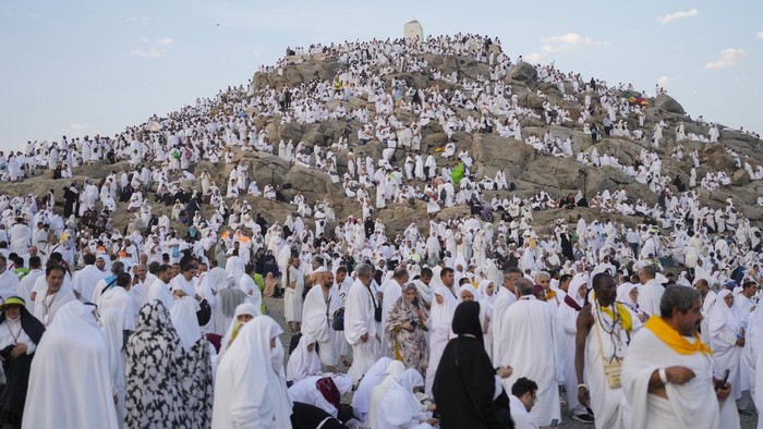 Muslim pilgrims gather at the top of the rocky hill known as the Mountain of Mercy, on the Plain of Arafat, during the annual Hajj pilgrimage, near the holy city of Mecca, Saudi Arabia, Saturday, June 15, 2024. Masses of Muslims gathered at the sacred hill of Mount Arafat in Saudi Arabia for worship and reflection on the second day of the Hajj pilgrimage. The ritual at Mount Arafat, known as the hill of mercy, is considered the peak of the Hajj. Its often the most memorable event for pilgrims, who stand shoulder to shoulder, asking God for mercy, blessings, prosperity and good health. Hajj is one of the largest religious gatherings on earth. (AP Photo/Rafiq Maqbool)