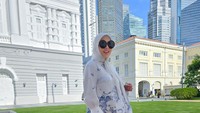 Dia berpose di depan Victoria Concert Hall dengan blouse berwarna putih-biru, dan jilbab senada.  Foto: Courtesy of Syahrini/ Instagram