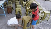 Jemaah yang masih kecil menata kursi yang akan digunakan untuk makan gratis (Foto: Ardian Dwi Kurnia)