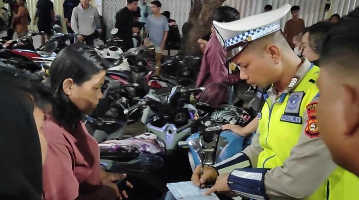 Petugas saat memberikan tilang kepada warga yang melakukan pelanggaran. Petugas saat memberikan tilang kepada warga yang melakukan pelanggaran.