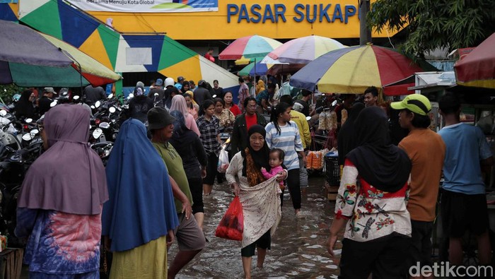 Potret Warga Belanja di Pasar Sukapura yang Terendam Banjir Sejumlah warga belanja kebutuhan Idul Adha di pasar yang terendam banjir kawasan Pasar Sukapura, Cilincing, Jakarta Utara, Minggu (16/6/2024).