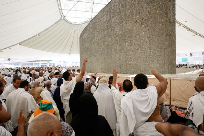 A woman reacts as Muslim pilgrims cast stones at a pillar symbolising Satan, during the annual haj pilgrimage in Mina, Saudi Arabia, June 16, 2024. REUTERS/Saleh Salem