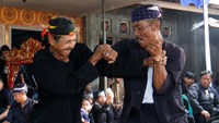Dua warga adu ketangkasan pada tradisi Pencak Sumping Mondoluko di Tamansuruh, Banyuwangi, Jawa Timur, Senin (17/6/2024).