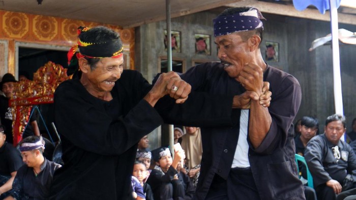 Dua warga adu ketangkasan pada tradisi Pencak Sumping Mondoluko di Tamansuruh, Banyuwangi, Jawa Timur, Senin (17/6/2024). Pertunjukan seni bela diri kuno yang ada sejak jaman penjajahan Belanda itu digelar rutin setiap Hari Raya Idul Adha selain sebagai upaya melestarikan tradisi para leluhur juga menjadi atraksi hiburan. ANTARA FOTO/Budi Candra Setya/nym.