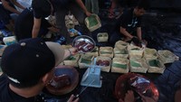 Petugas mengemas daging hewan kurban ke dalam besek bambu saat pemotongan hewan kurban di Jakarta, Senin (17/6/2024).
