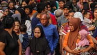 Sebagian warga ada yang membawa anaknya saat antre daging kurban.