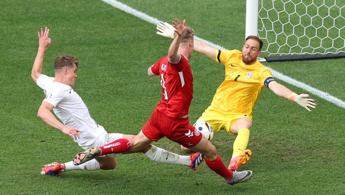 STUTTGART, GERMANY - JUNE 16: Rasmus Hojlund of Denmark has a shot saved by Jan Oblak of Slovenia whilst under pressure from Jaka Bijol of Slovenia during the UEFA EURO 2024 group stage match between Slovenia and Denmark at Stuttgart Arena on June 16, 2024 in Stuttgart, Germany.   (Photo by Carl Recine/Getty Images)