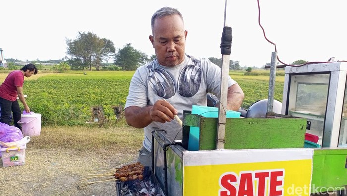 Sertu Sarijo saat berjualan sate kronyos di JJLS, tepatnya sekitar Jembatan Kretek II, Kretek, Bantul, Senin (17/6/2024).