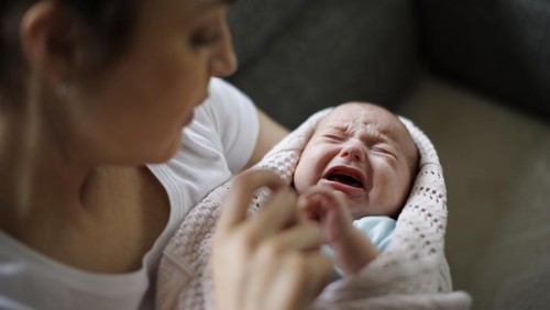 Newborn baby crying in mothers hands