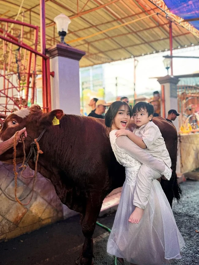 Fuji merayakan Idul Adha 2024 bersama keluarganya. Sebuah unggahan memperlihatkan potret Fuji menggendong keponakan kesayangan, Gala, di samping seekor sapi. Duo tante-keponakan itu kompak berbaju putih. (Foto: Instagram)