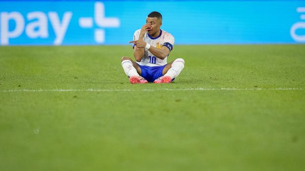 Kylian Mbappe dari Prancis duduk di lapangan, menyerahkan hidungnya yang berdarah, saat pertandingan Grup D antara Austria dan Prancis pada turnamen sepak bola Euro 2024 di Duesseldorf, Jerman, Senin, 17 Juni 2024. (AP Photo/Andreea Alexandru)