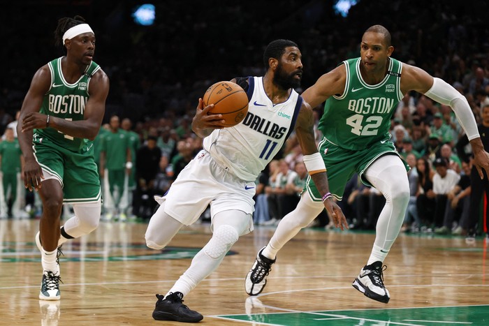 Jun 17, 2024; Boston, Massachusetts, USA; Dallas Mavericks guard Kyrie Irving (11) drives to the basket against Boston Celtics guard Jrue Holiday (left) and center Al Horford (right) during the second quarter in game five of the 2024 NBA Finals at TD Garden. Mandatory Credit: Peter Casey-USA TODAY Sports