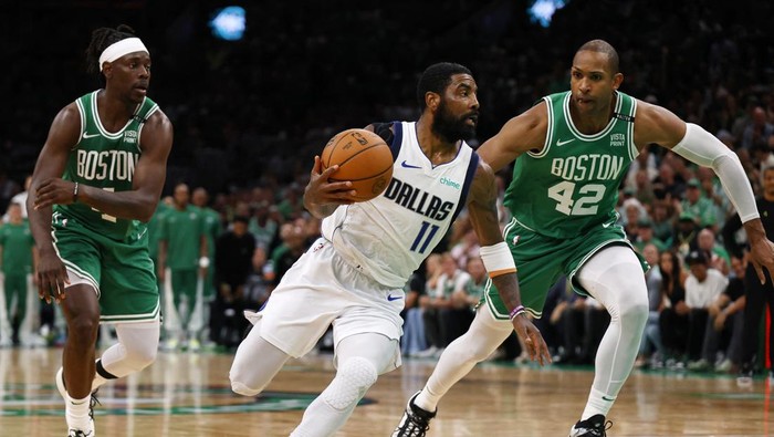 Jun 17, 2024; Boston, Massachusetts, USA; Dallas Mavericks guard Kyrie Irving (11) drives to the basket against Boston Celtics guard Jrue Holiday (left) and center Al Horford (right) during the second quarter in game five of the 2024 NBA Finals at TD Garden. Mandatory Credit: Peter Casey-USA TODAY Sports