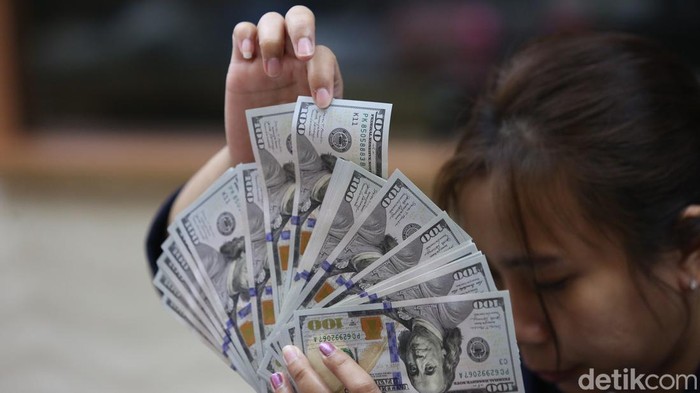 Karyawan membuktikan duit dolar Amerika Serikat (AS) dan Rupiah di salah satu gerai penukaran mata duit absurd di Jakarta, Selasa (18/6/2024).