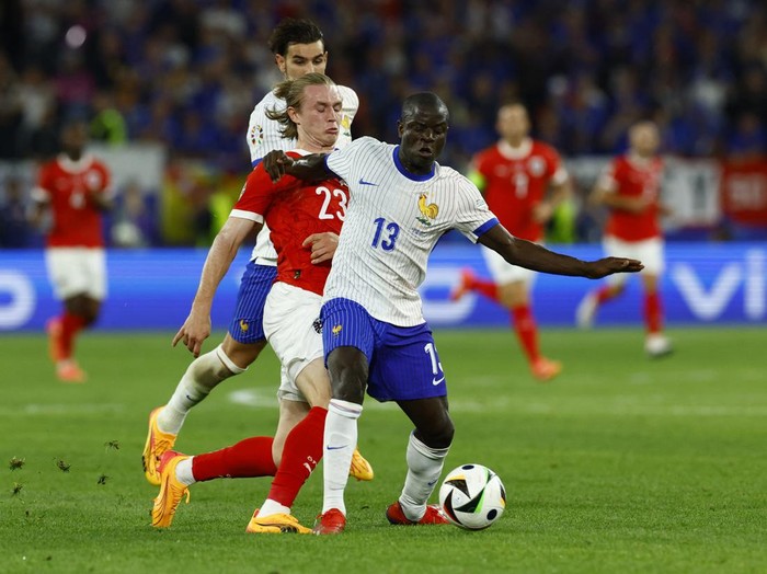 Soccer Football - Euro 2024 - Group D - Austria v France - Dusseldorf Arena, Dusseldorf, Germany - June 17, 2024 France's Theo Hernandez and N'Golo Kante in action with Austria's Patrick Wimmer REUTERS/Piroschka Van De Wouw