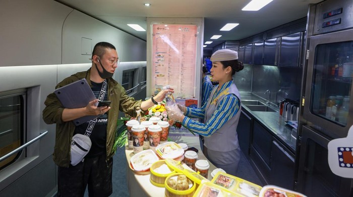 BEIJING, CHINA - JUNE 15: A passenger with a child rides the high-speed sleeper train D909 bound for Hong Kong's West Kowloon Station at Beijing West Railway Station on June 15, 2024 in Beijing, China. High-speed sleeper trains connecting Beijing and Shanghai to Chinese Hong Kong started operations on June 15. (Photo by Jia Tianyong/China News Service/VCG via Getty Images)