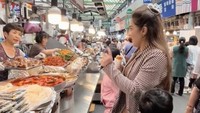 Tak ketinggalan, Ashanty dan Arsy mencicipi tteokbokki dan gimbab di salah satu gerai. Mereka asyik makan di pasar tradisional yang makin terkenal usai masuk Netflix ini. Foto: TikTok Ashanty Hermansyah