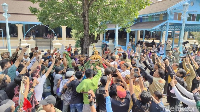 Warga berebut gunungan saat Grebeg Besar di Masjid Agung Solo, Selasa (18/6/2024).