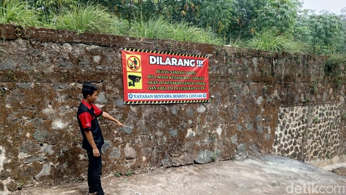Warga memperlihatkan tempat terlarang untuk membuang sampah di Tanjungsari, Sumedang