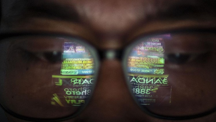 Refleksi warga saat melihat iklan judi online melalui gawainya di Jakarta, Rabu (19/6/2024). Kementerian Komunikasi dan Informatika (Kominfo) telah memblokir sebanyak 2,1 juta situs web untuk memberantas perjudian dalam jaringan atau online di Indonesia. ANTARA FOTO/Aprillio Akbar/rwa.