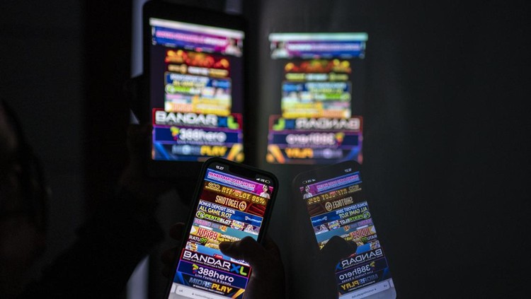 Refleksi warga saat melihat iklan judi online melalui gawainya di Jakarta, Rabu (19/6/2024). Kementerian Komunikasi dan Informatika (Kominfo) telah memblokir sebanyak 2,1 juta situs web untuk memberantas perjudian dalam jaringan atau online di Indonesia. ANTARA FOTO/Aprillio Akbar/rwa.