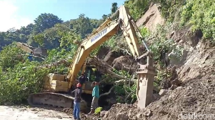 Longsor di Tompo Ladang menimbun alat berat dan menutupi badan jalan.