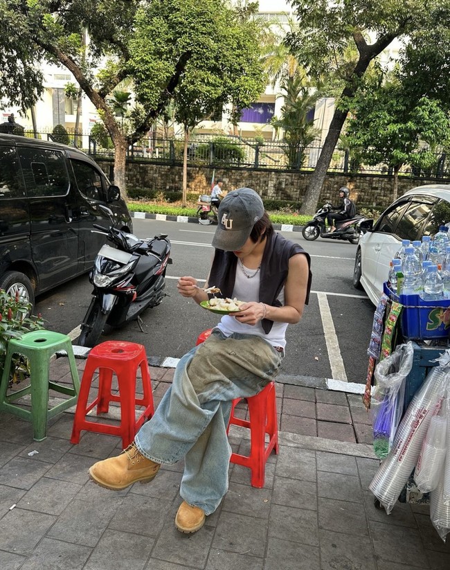 Solois Korea, Leo makan ketoprak di dekat penjual ‘starling’ di Lapangan Banteng Jakarta. Foto yang dibagikannya Selasa (18/6/2024) kemarin sontak menjadi perbincangan netizen Indonesia di media sosial. Penggemar tak menyangka Leo akan melokal, duduk di kursi plastik merah. Foto: Instagram