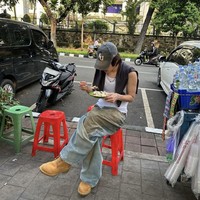 Solois Korea, Leo makan ketoprak di dekat penjual ‘starling’ di Lapangan Banteng Jakarta. Foto yang dibagikannya Selasa (18/6/2024) kemarin sontak menjadi perbincangan netizen Indonesia di media sosial. Penggemar tak menyangka Leo akan melokal, duduk di kursi plastik merah. Foto: Instagram