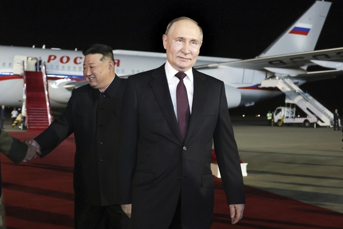Russian President Vladimir Putin, right, walks as North Koreas leader Kim Jong Un shakes hands with the Russian delegation during their meeting at the Pyongyang Sunan International Airport outside Pyongyang, North Korea, on Tuesday, June 18, 2024. (Gavriil Grigorov, Sputnik, Kremlin Pool Photo via AP)