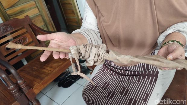 Rita menunjukan pecut atau benda seperti ranting pohon yang didapat kakeknya dari Pulo Majeti, konon sebagai sarana Raja Onom datang untuk Tradisi Kuda Kosong.