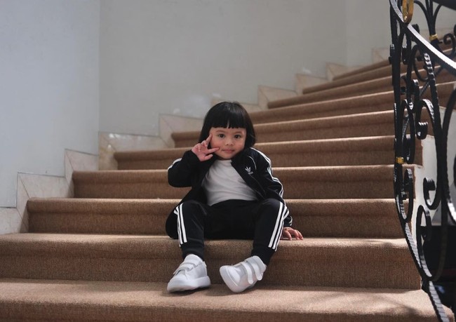 Ada pula momen Ameena bergaya di tangga dalam setelan sporty Adidas warna hitam-putih. Cocok dengan sneakers dengan aksen strap yang full putih. Foto: Instagram @ameenaatta