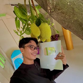Ardiansyah berfoto di depan pohon nangka miliknya sembari memegang silver button dari YouTube.