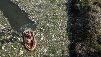 Sampah tersebut bercampur dengan tanaman liar yang tubuh subur di aliran Sungai Citarum.  