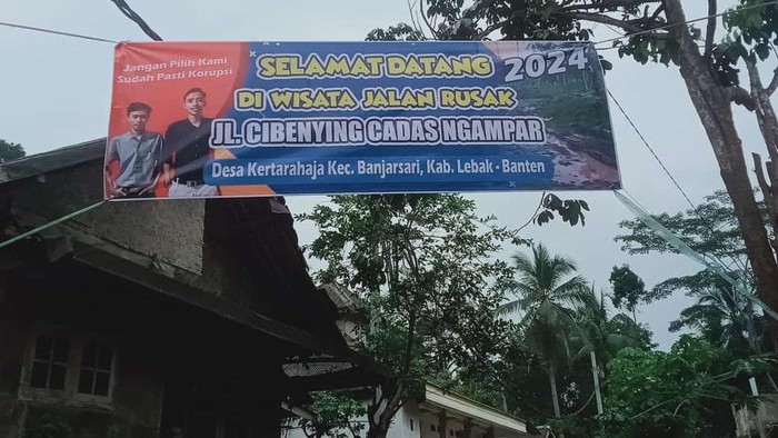 Spanduk bertuliskan Selamat Datang di Wisata Jalan Rusak terbentang di Jl Cibenying Cadas Ngampar, Desa Kertarahaja, Kecamatan Banjarsari, Lebak, Banten. (Foto: dok. istimewa)
