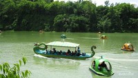 Wisatawan menggunakan perahu naga untuk mengelilingi pulau di Waduk Pejengkolan.