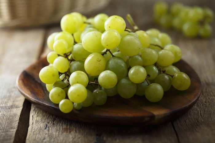 Ripe white grape on wooden desk
