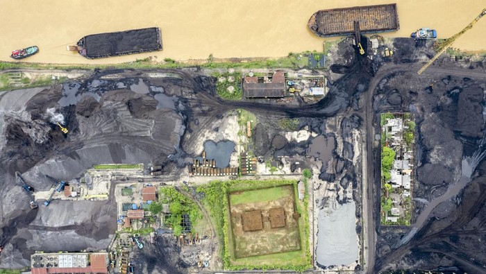 Batu bara di zona inti KCBN Muara Jambi Foto udara Candi Teluk 1 yang sekitar lokasinya dijadikan penampungan batu bara, tepi Sungai Batanghari, Muaro Jambi, Jambi, Kamis (20/6/2024). Beberapa kawasan sekitar situs candi, utamanya di bagian selatan Kawasan Cagar Budaya Nasional (KCBN) Muara Jambi atau masuk dalam zona inti berdasarkan Keputusan Mendikbudristek tentang Sistem Zonasi Kawasan Cagar Budaya Peringkat Nasional Muara Jambi masih di kelilingi aktivitas bongkar muat batu bara dan perkebunan. ANTARA FOTO/Wahdi Septiawan/Spt.