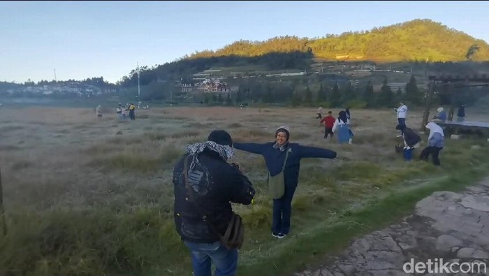 Wisatawan berburu embun es di komplek Candi Arjuna Dieng, Jumat (21/6/2024).