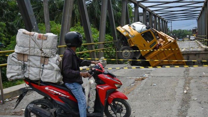 Dilintasi Damtruk, Jembatan di Langkat Ambrol Pengendara sepeda motor berputar arah ketika akan melintas di Jembatan Sei Air Tenang yang ambrol, di Padang Tualang, Langkat, Sumatera Utara, Kamis (20/6/2024). Jembatan penghubung antara Kecamatan Padang Tualang dan Batang Serangan yang menjadi jalur menuju objek wisata Tangkahan tersebut ambrol saat dilewati mobil damtruk bermuatan pasir dan batu yang melebihi muatan pada Selasa (11/6) lalu. ANTARA FOTO/Fransisco Carolio/rwa.