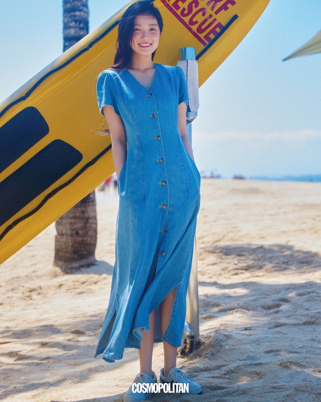 Menjelma jadi Island Girl. Kim Hye Yoon memakai gaun denim panjang, berpose di depan papan selancar. Rambutnya panjangnya dibiarkan terurai saat ke pantai. Foto: dok. Cosmopolitan Korea