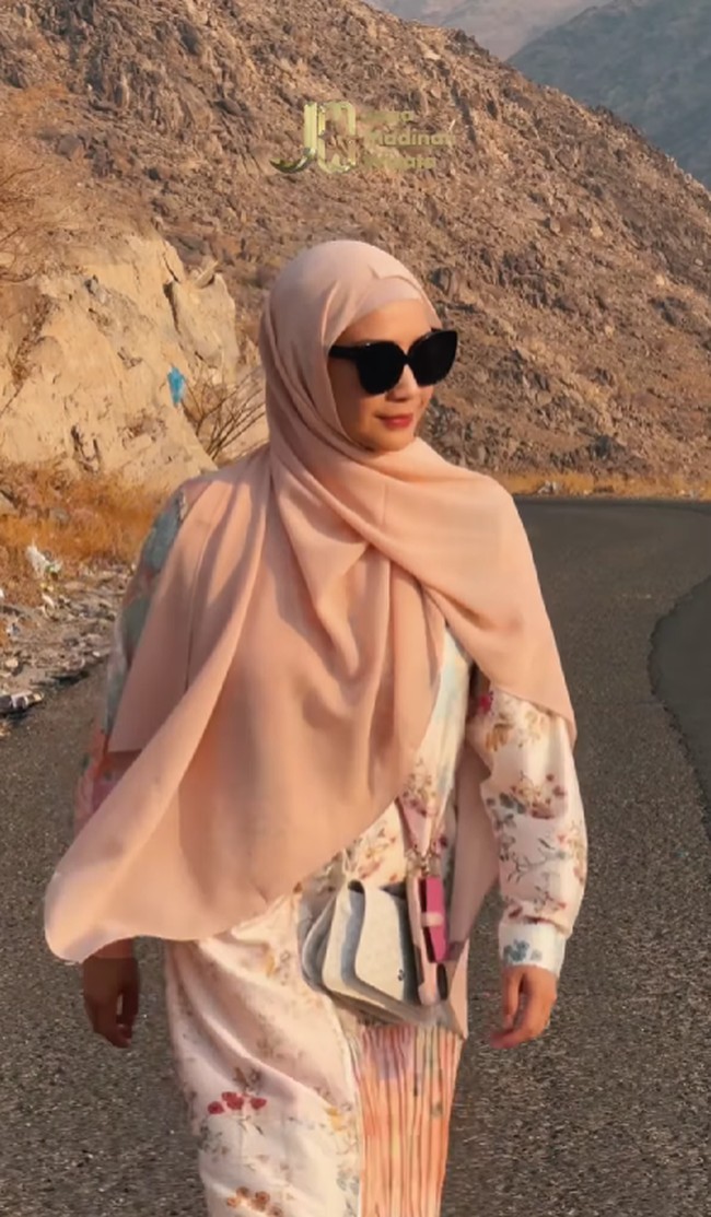 Gigi tampil memesona saat memakai dress warna putih dan coral dengan motif floral. Ada detail pleats pada bagian bawah dress. Gigi melengkapi gayanya dengan tas Goyard Plumet Pocket Wallet seharga Rp 21,4 Juta. Foto: Dok. Instagram @raffinagita1717.