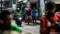 Dengan bobot 10 kilogram Nopal mengarak ondel-ondel hingga ke dalam perkampungan warga.