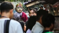 Pengamen ondel-ondel melintas di antara aktivitas warga di Ibu Kota.