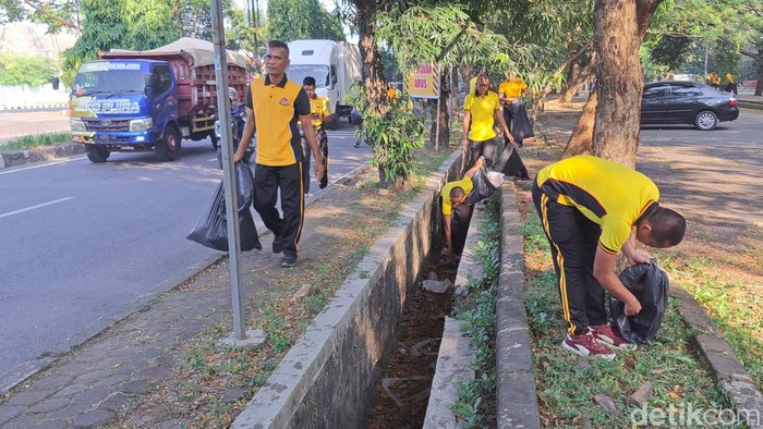 Polisi saat memungut sampah berserakan di jalanan Cirebon