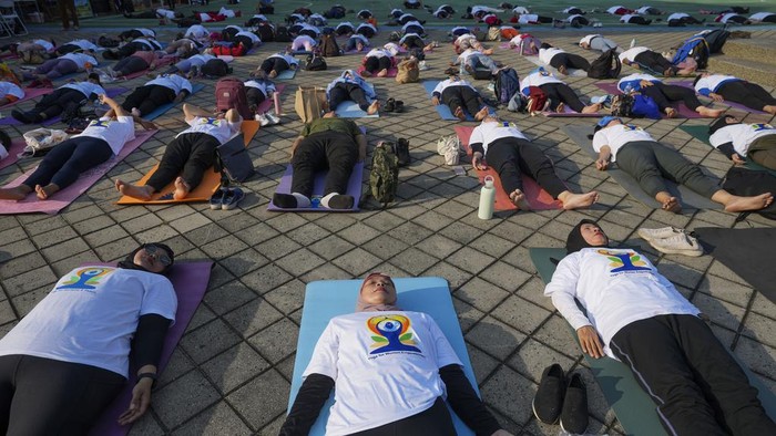 People practice yoga in an International Yoga Day event organized by the Embassy of India, at the Youth and Sports Ministry in Jakarta, Indonesia, Friday, June 21, 2024. (AP Photo/Tatan Syuflana)