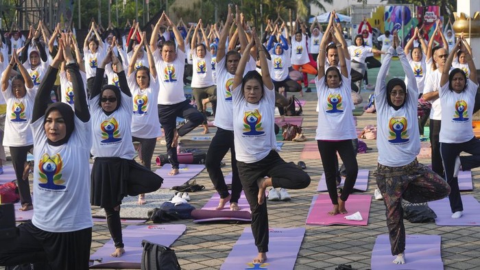 People practice yoga in an International Yoga Day event organized by the Embassy of India, at the Youth and Sports Ministry in Jakarta, Indonesia, Friday, June 21, 2024. (AP Photo/Tatan Syuflana)