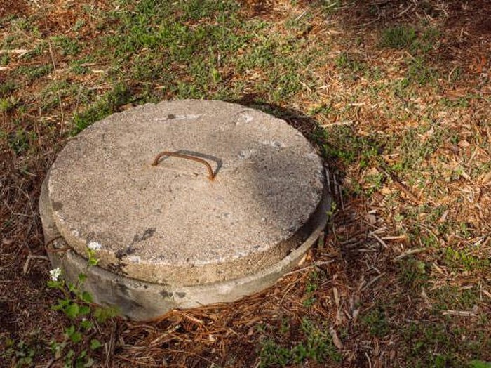 Septic tank lid cover made of concrete. Domestic sewage concept for environmental issues, home owner problems, hygiene, or waste management for home owners.